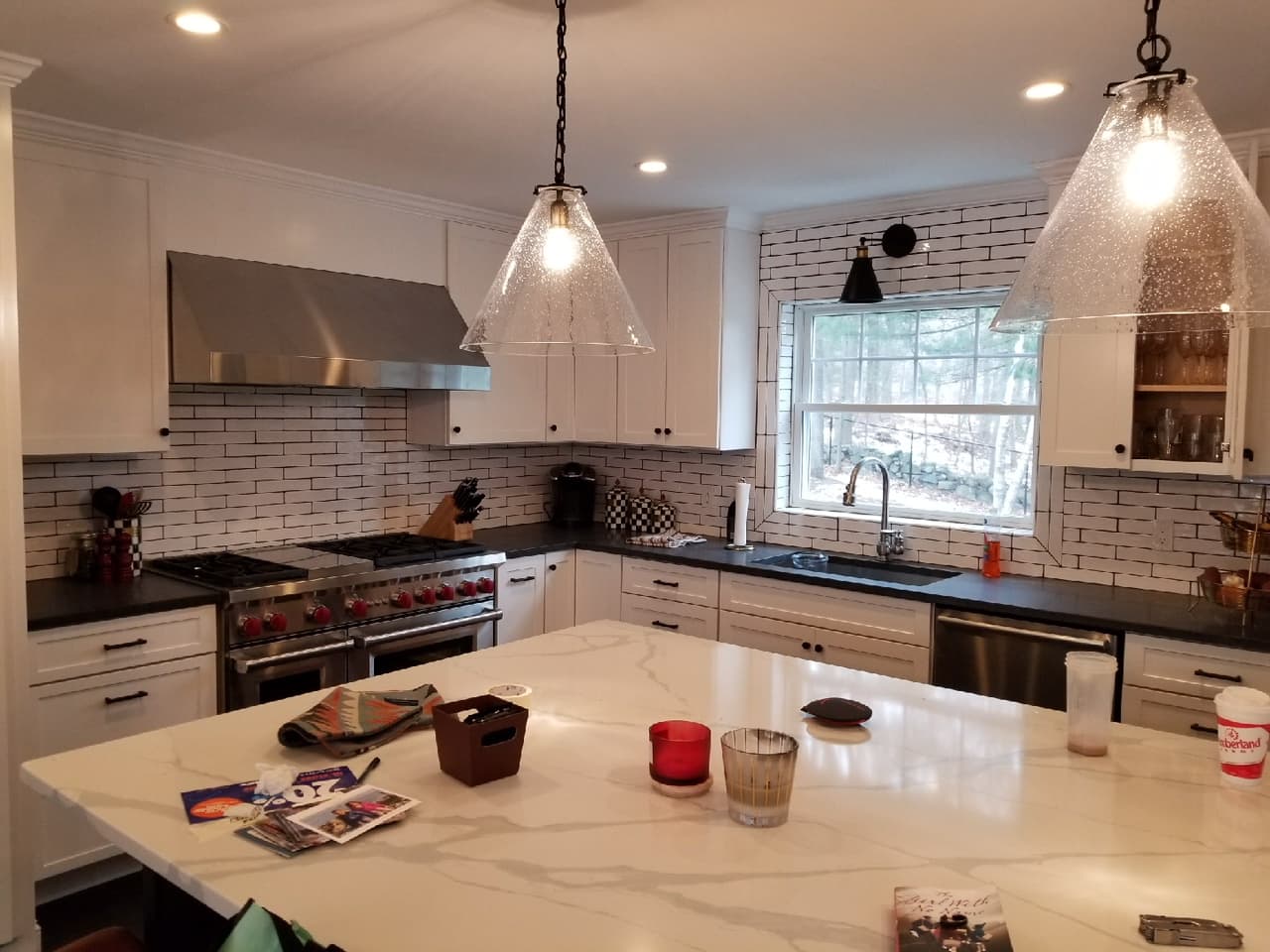 Finished kitchen with white cabinets and marble-look island