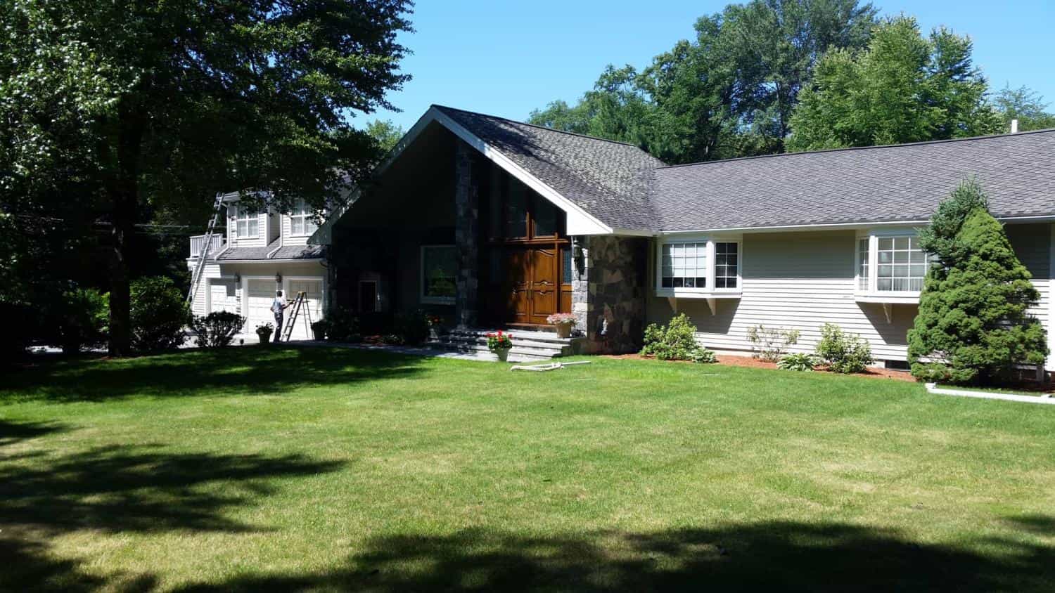 Large house with a stone front and gray siding