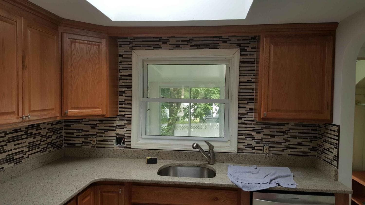 Wood kitchen cabinets with a new glass mosaic backsplash