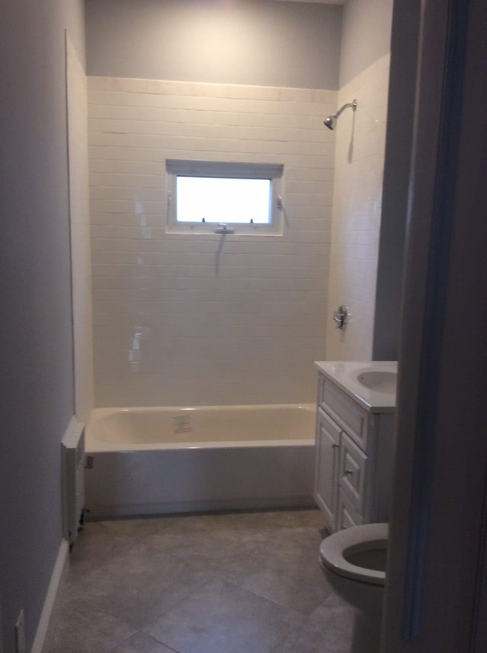 Bathroom with a white subway tile tub surround and new vanity