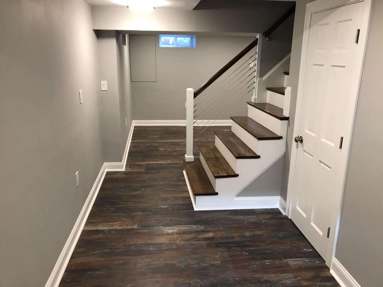 Finished basement with plank floors and white interior doors