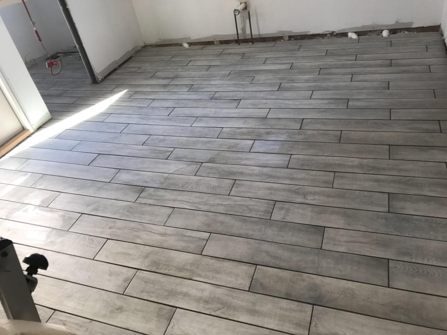 Wood-look tile floor being installed