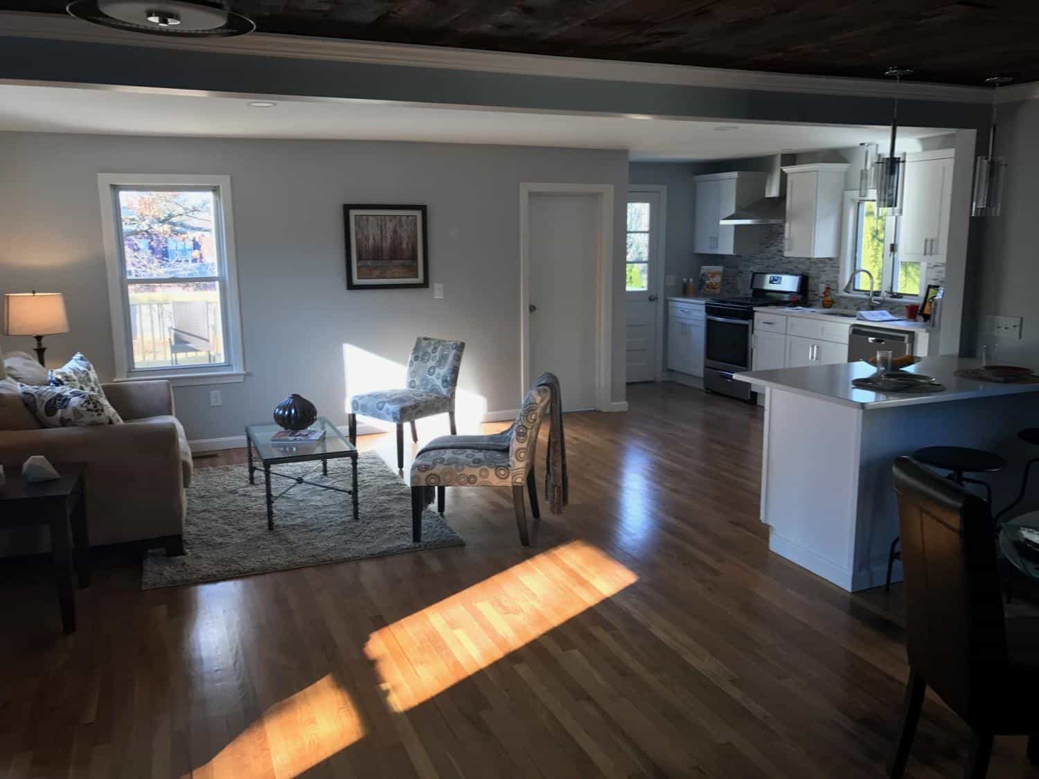 Living room and kitchen with hardwood floors from a DT Painting & Services job