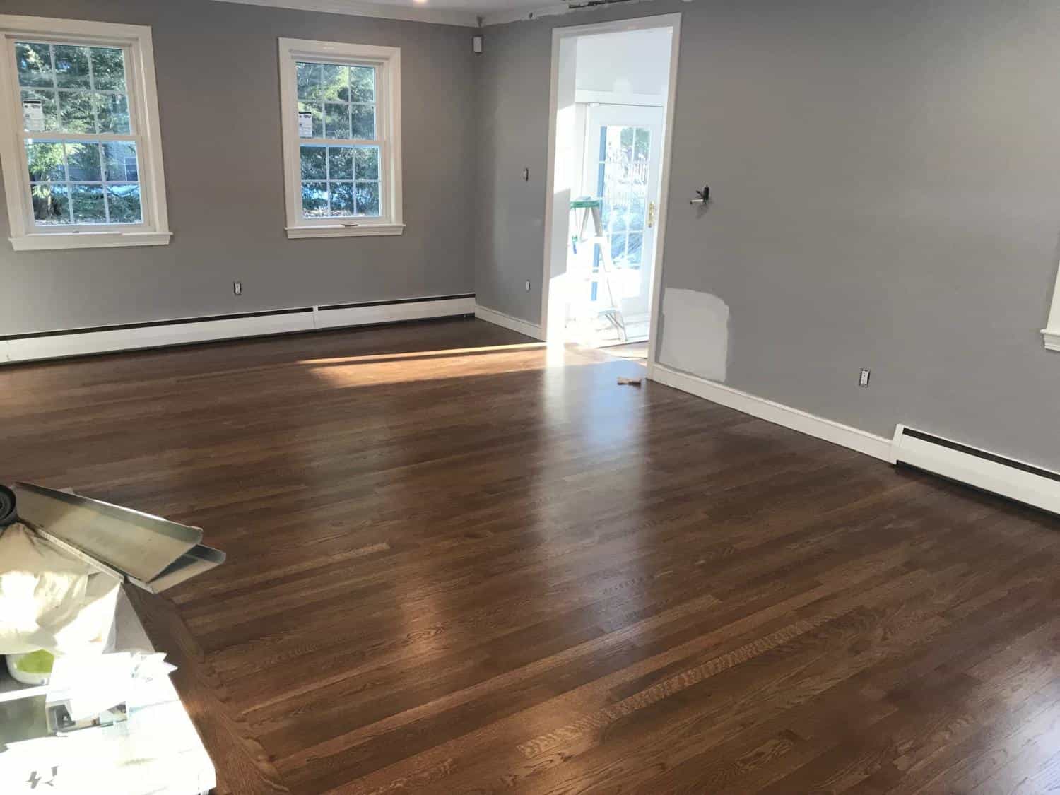Living room painted gray with white trim and hardwood floors