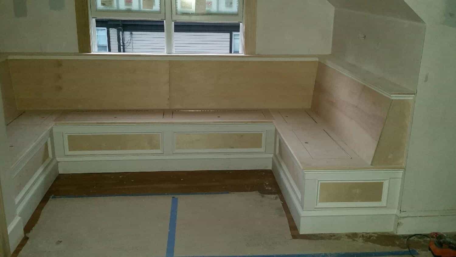 Window seat framed and paneled under a row of windows