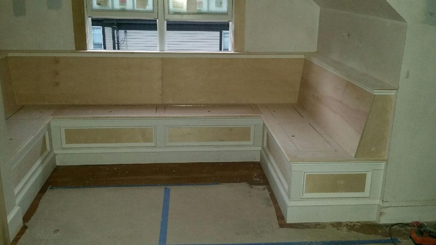 Built-in window seat being built under a bay of windows