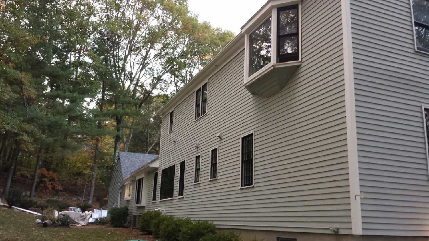 Side of a two-story colonial with freshly painted siding
