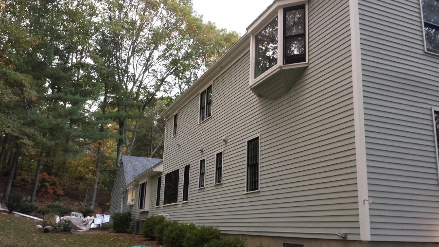 Side of a two-story colonial with freshly painted siding