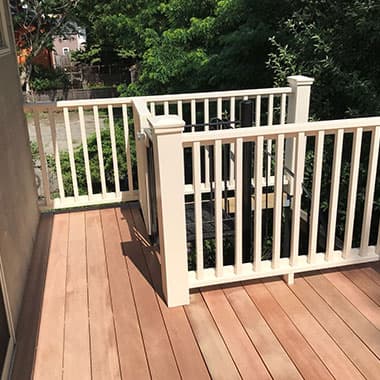 Wood deck with white rail posts and balusters