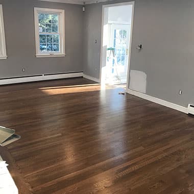 Room with new plank floors, gray walls and white trim