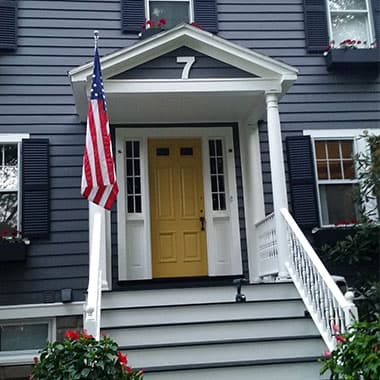 Navy blue house with a yellow front door, freshly painted
